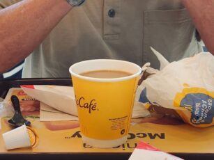 A man sitting at a table with a cup of coffee.